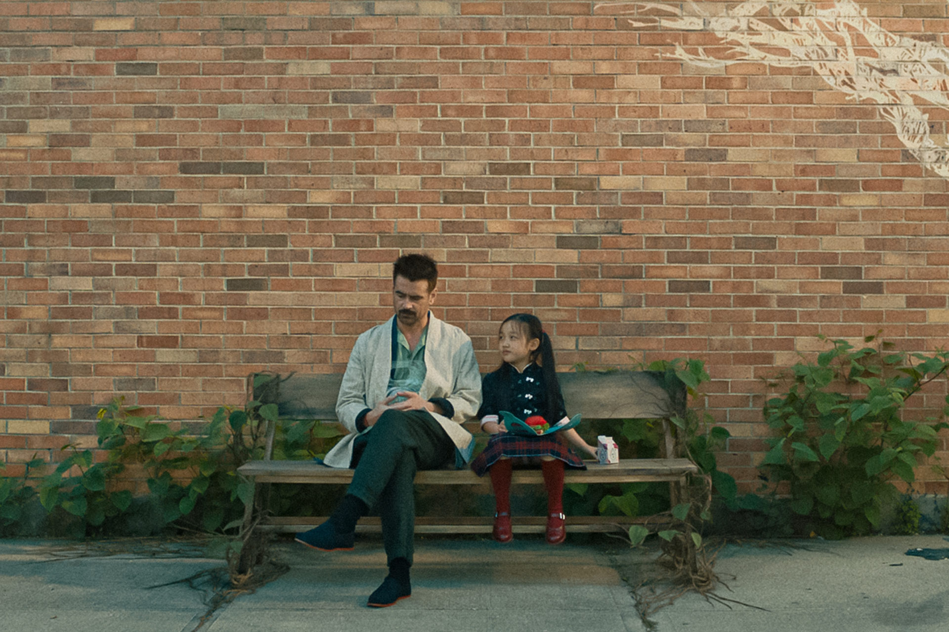 Un androïde et une petite fille sur un banc.